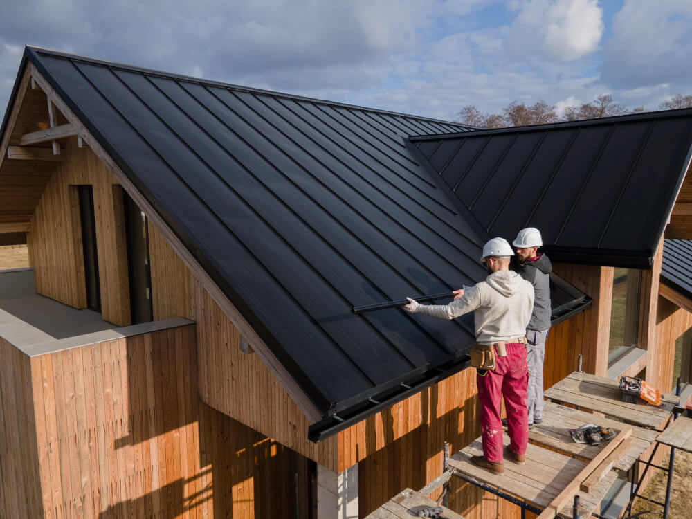 Close-up of a roofer fitting tiles by hand with gloves