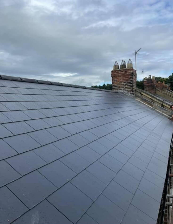 New clay tiles being laid on a pitched roof