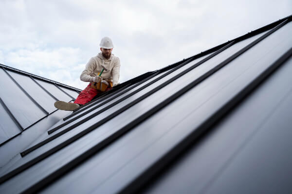 Roofer working on roof framing with high-vis kit